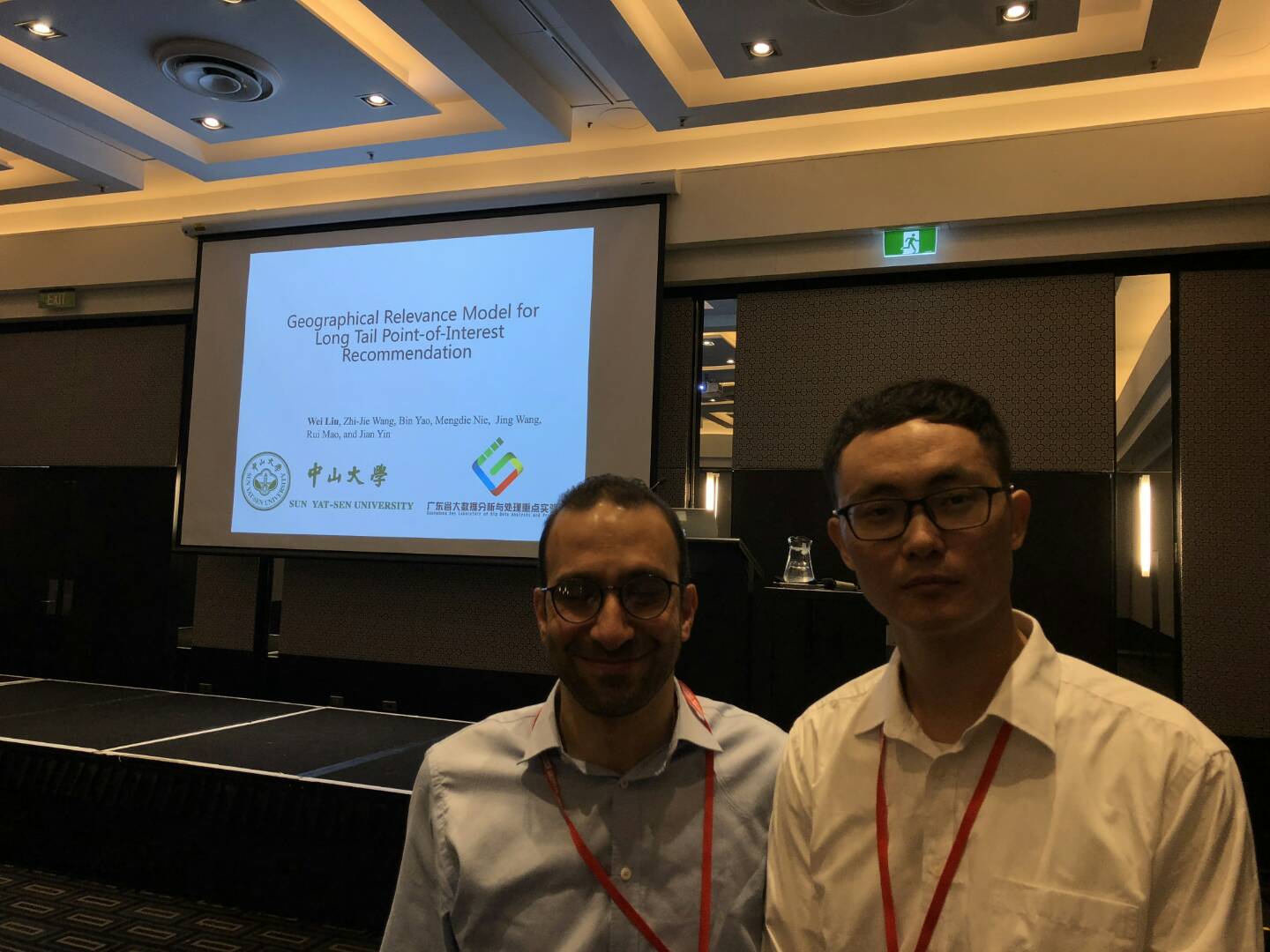 图3 团队成员刘威作技术报告并与主持人Saeid Hosseini博士合影